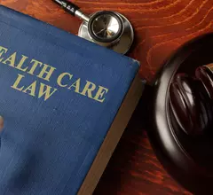 A book titled "Health Care Law" next to a gavel and a stethoscope 
