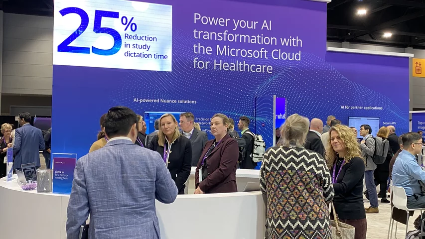 Nuance booth with messaging on how AI and improve workflow and radiologist efficiency. Nuance demonstrated a new AI implementation that can help automate more the of radiology report with less work by the radiologist. Solutions like this were highlighted across the expo floor because of the growing shortage of radiologists. Nuance AI workflow messaging at its booth at RSNA 2023. Photo by Dave Fornell. #RSNA #RSNA23 #RSNA2023