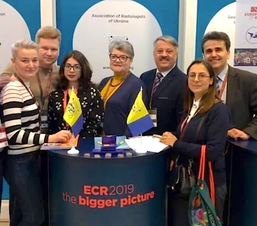 Nikolai Bortny (with mustache, third from the right), associate professor of radiology diagnostics at Kharkiv Medical Academy, and other members of the Association of Radiologists in Ukrainian pose for a picture at their booth on the expo floor at the European Society of Radiology 2019 meeting. Bortny has been under regular bombardment in Kharkiv since the start of the Russian invasion two months ago. #standwithUkraine