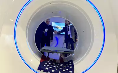 A handshake during a meeting inside a trailer designed for disasters or military use with a mobile iCRco Claris XT CT system. Photo by Dave Fornell. #RSNA #RSNA23 #RSNA2023